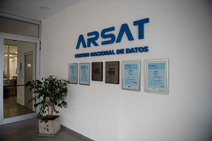 Entrada del Centro Nacional de Datos, en sus paredes está el logo de Arsat y seis cuadros de las certificaciones TIER tres e ISO en inglés y castellano.